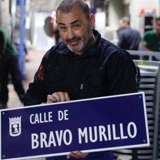 Pie de foto: Un operario de Api-fabricación sostiene la placa de la calle de Bravo Murillo en el distrito de Tetuán ©Felipe Nombela