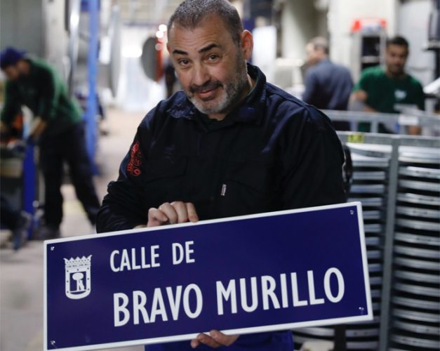 Pie de foto: Un operario de Api-fabricación sostiene la placa de la calle de Bravo Murillo en el distrito de Tetuán ©Felipe Nombela