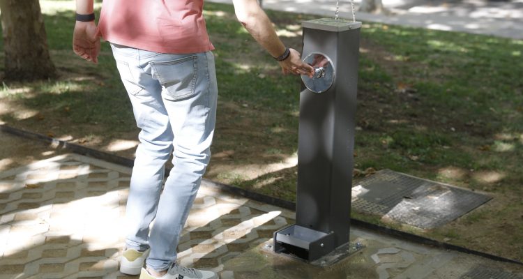 Joven utiliza una fuente de agua potable